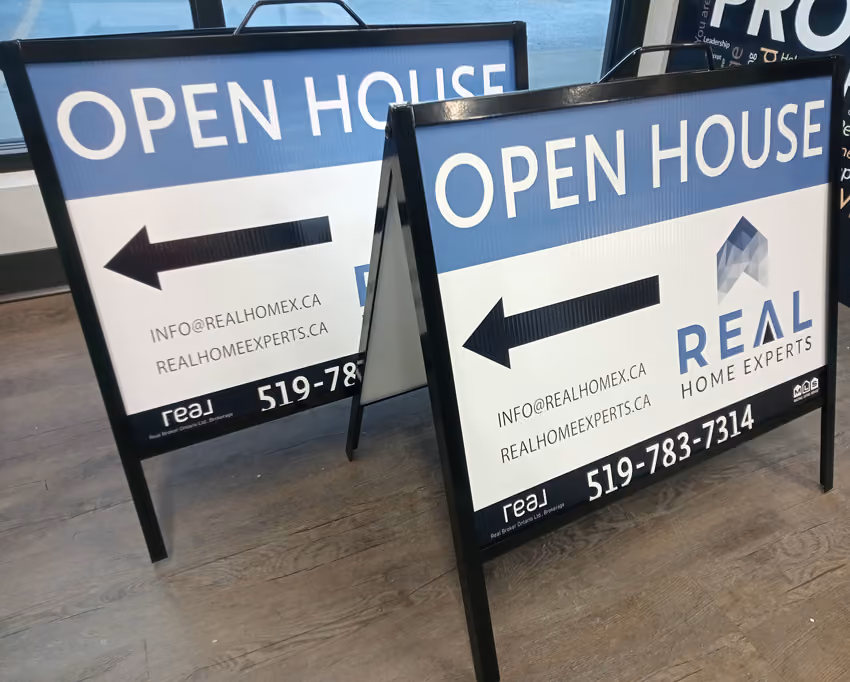 Photo of two portable A-Frame signs with wording "Open House", arrows and Real Home Experts branding and contact details