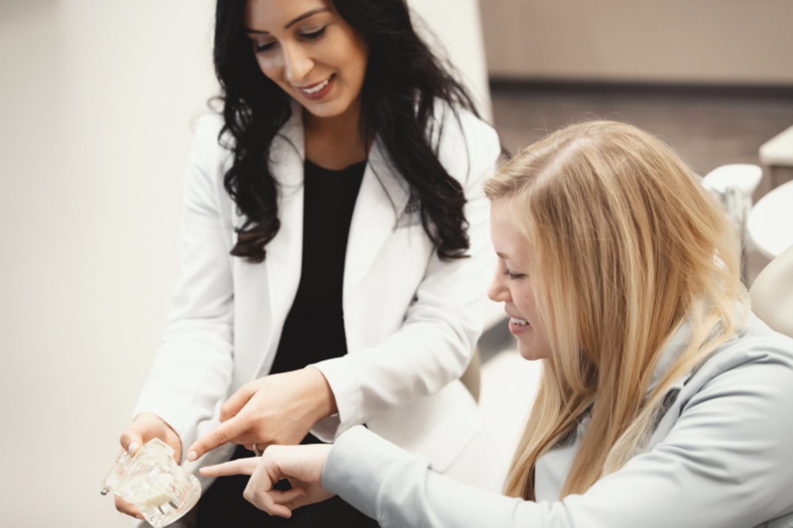 Female dentist discussing treatment options with patient in SmilesHUB office consultation room.