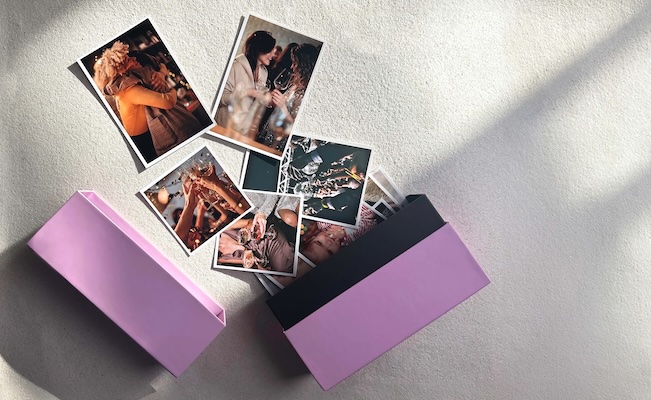 Klikkie Memory Box with printed photos inside, sitting on a bookshelf