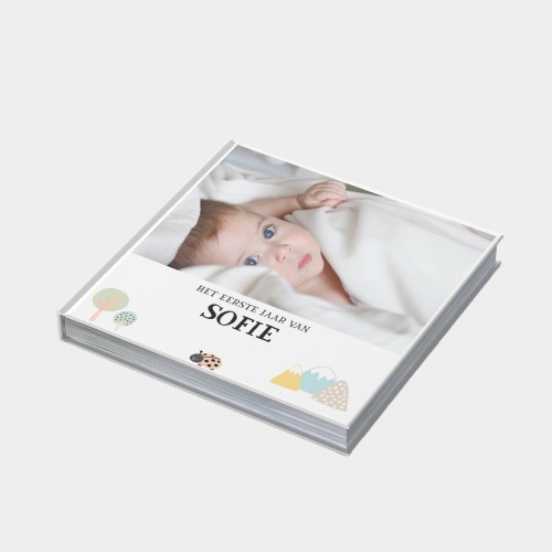klikkie baby photo book open on a table showing a baby's first year milestones
