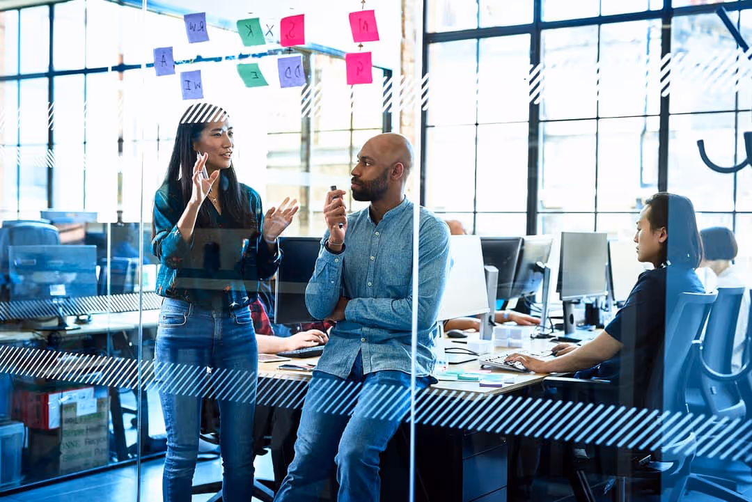 A group of designers brainstorming in front of a whiteboard. 