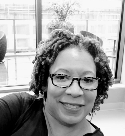 A black and white image of Francine Thompson in front of a bright, open window