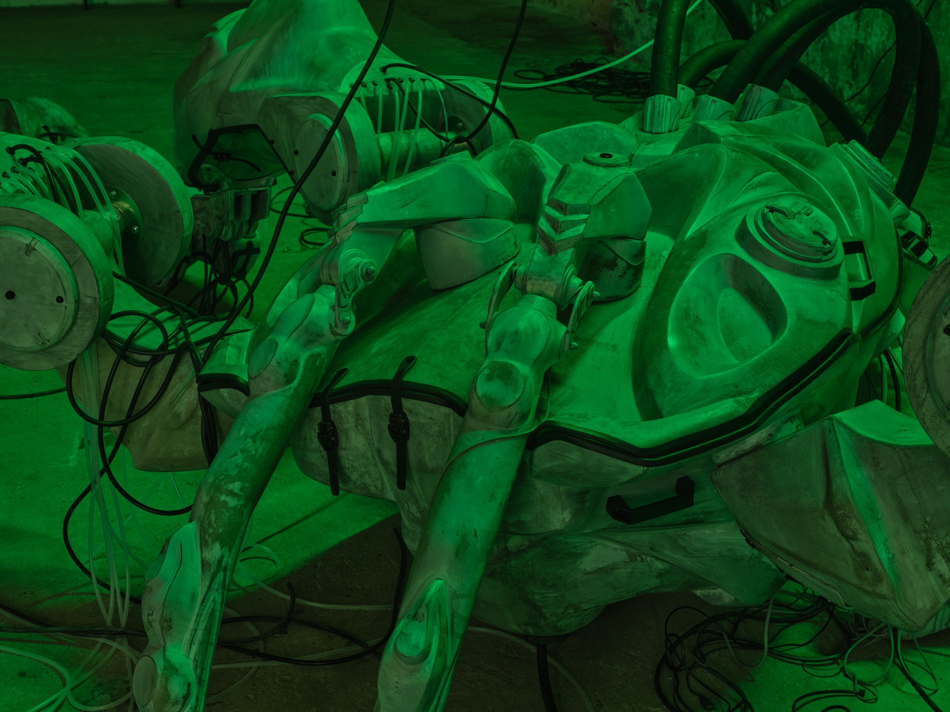 Detail of Mecha (protective suit) by Davide Allieri, cable terminus and sculpture base on industrial floor, 2026