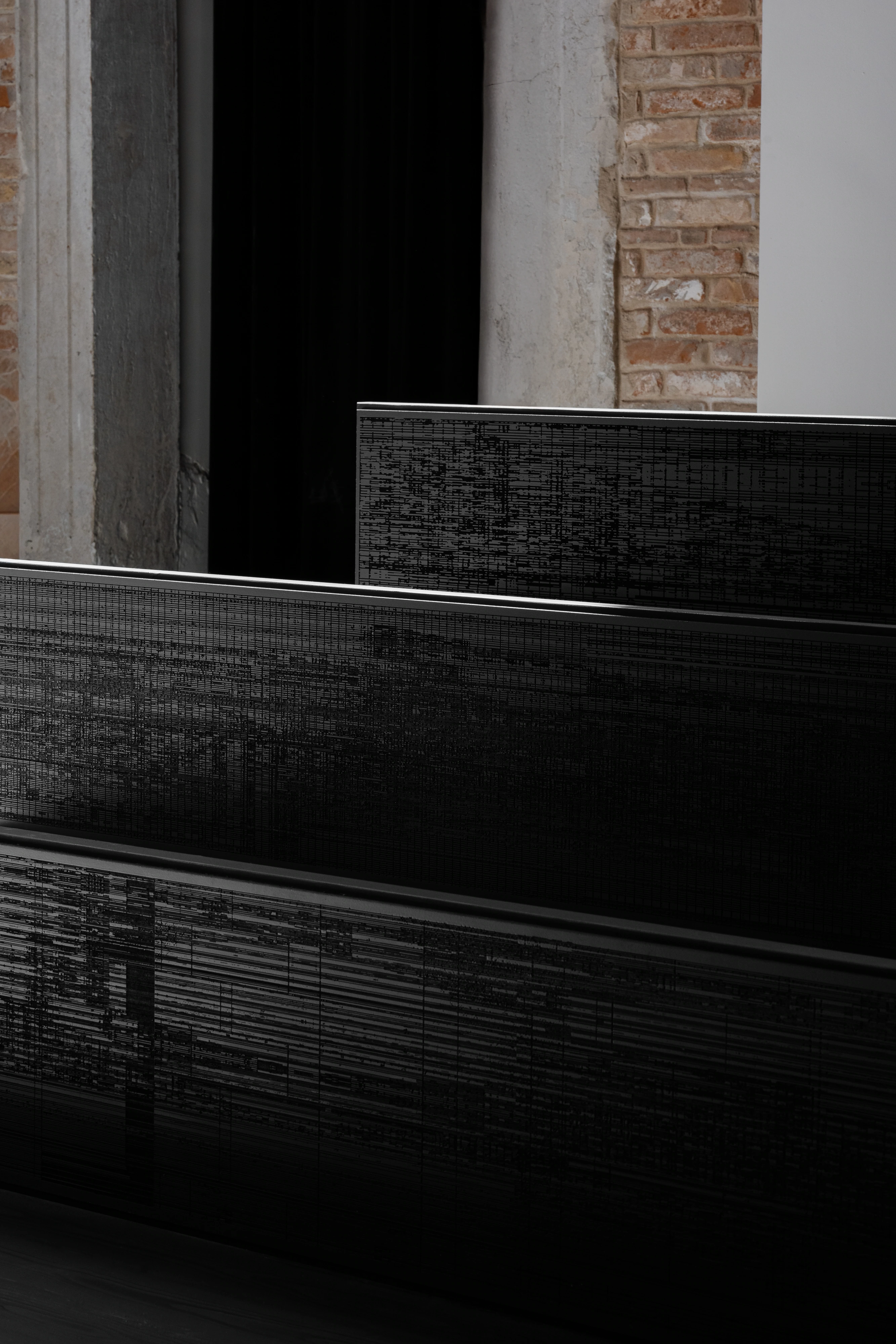 Mat Dryhurst and Holly Herndon, close-up of bench surface with dense etched data-noise grid lines on matte black panel, Strange Rules, Palazzo Diedo, Venice