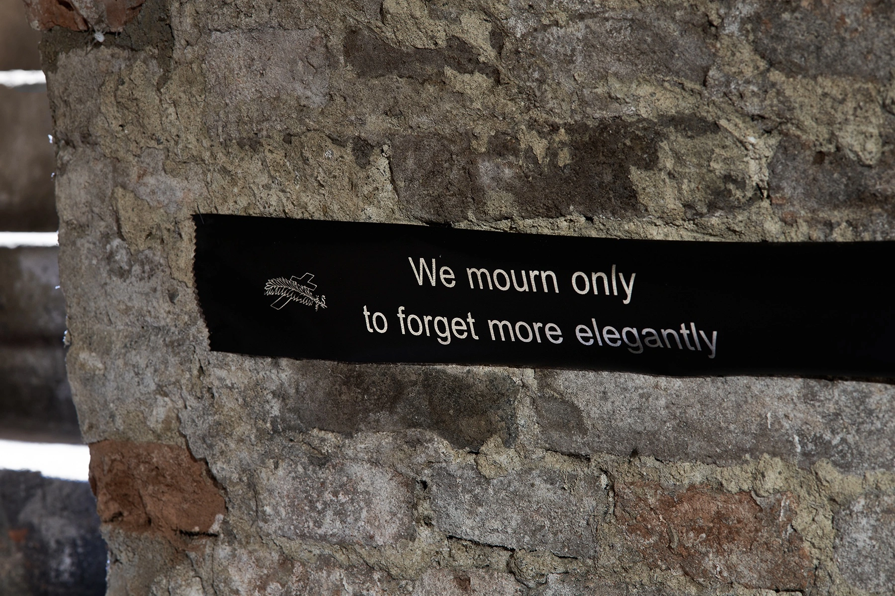 Anzhelika Palyvoda, text panel on brick reading 'We mourn only to forget more elegantly', vaulted passage, FAVU Gallery, 2026