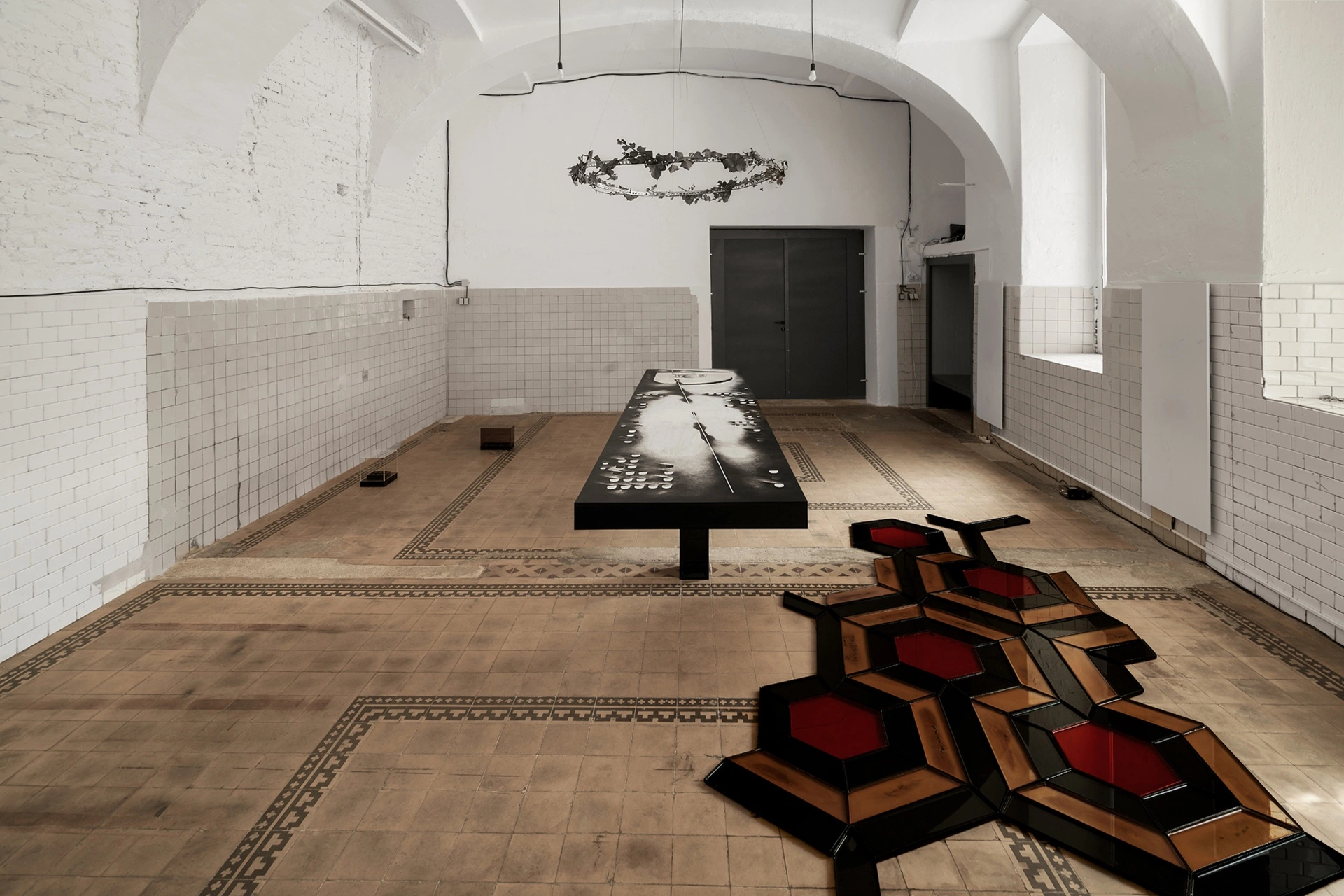 Installation views of Echoes That Refuse to Fade at FAVU Gallery Brno, featuring ceramic sculpture, hexagonal floor grids, dissection table painting, mirror installations, and perforated light works by Yesakova, Struger, and Palyvoda.