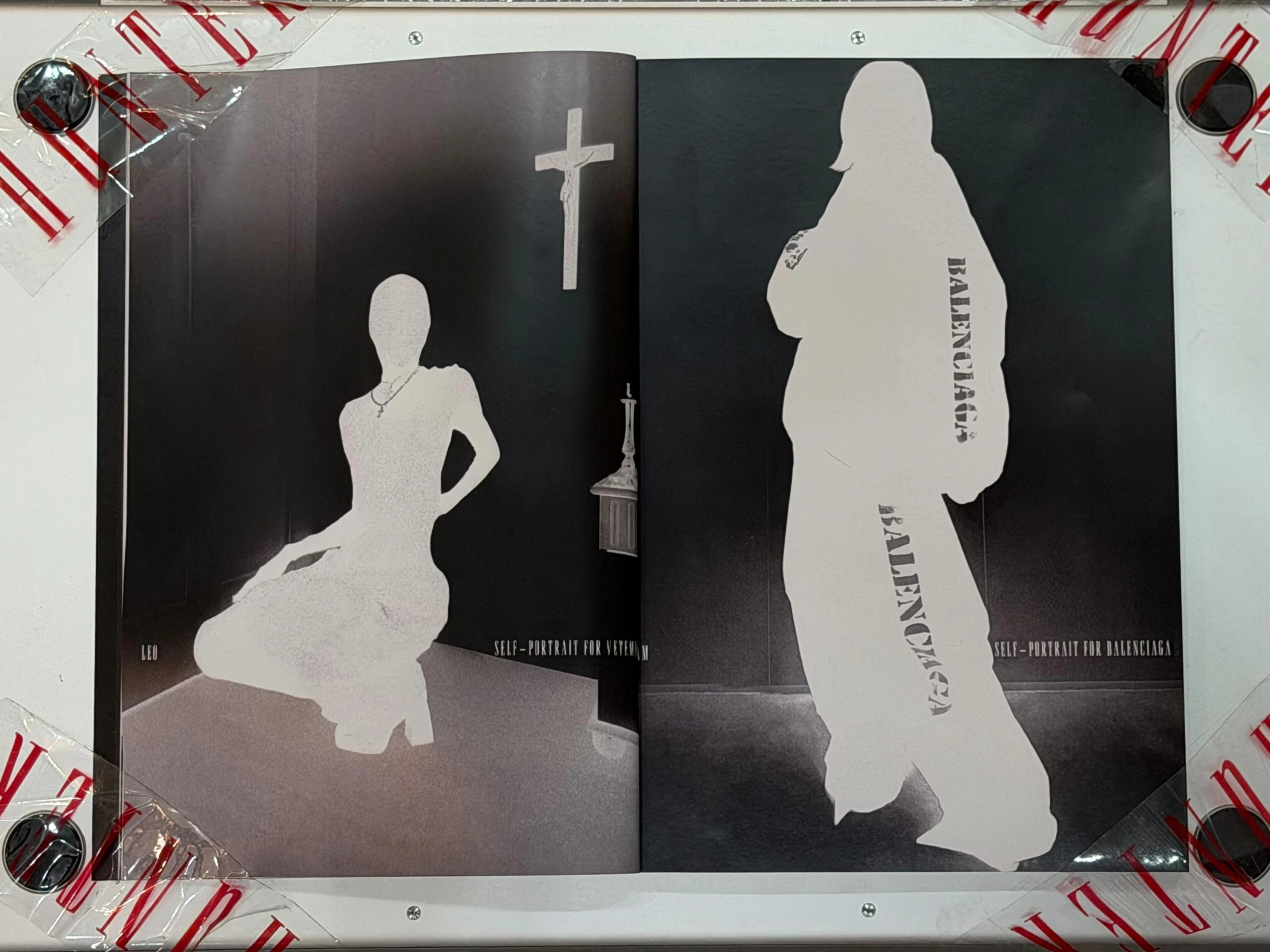Spread pages from TheHunterIssue Vol.1 by Leo Shmunk. Veiled figures under a white cross, brand silhouettes drained to monochrome, ANONYMOUS CLUB debossing, marble-paper Chanel double-C residue. Print only, 2026.