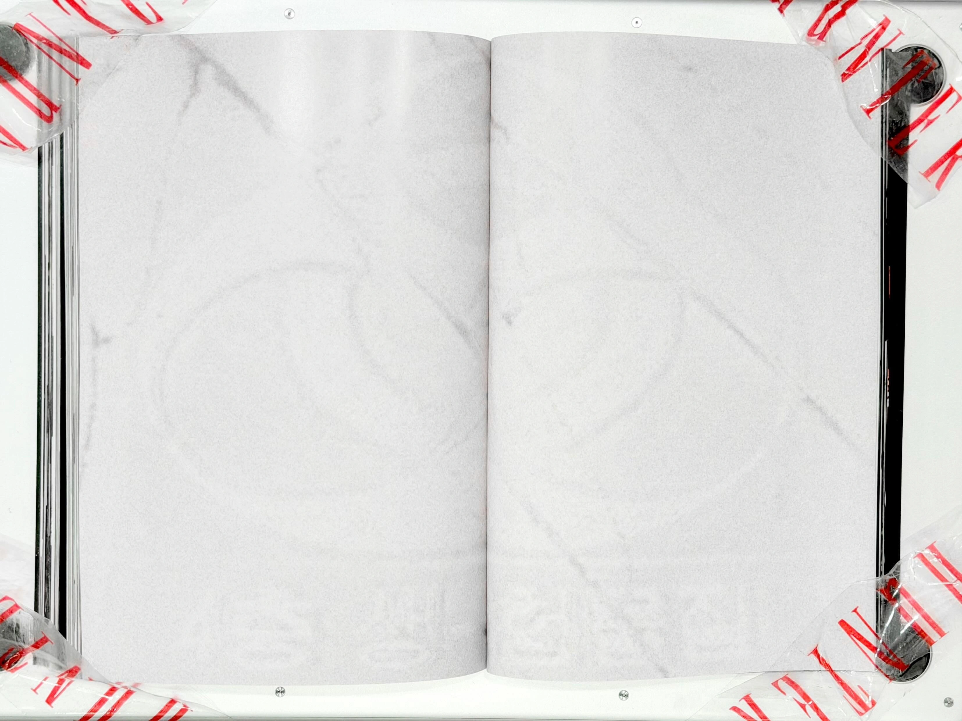 Spread from TheHunterIssue Vol.1 by Leo Shmunk, photograph of a Vetements tracksuit drained to grey-on-black with mid-air water motion, opposite page debossed with ANONYMOUS CLUB under the TheHunterIssue logo, 2026