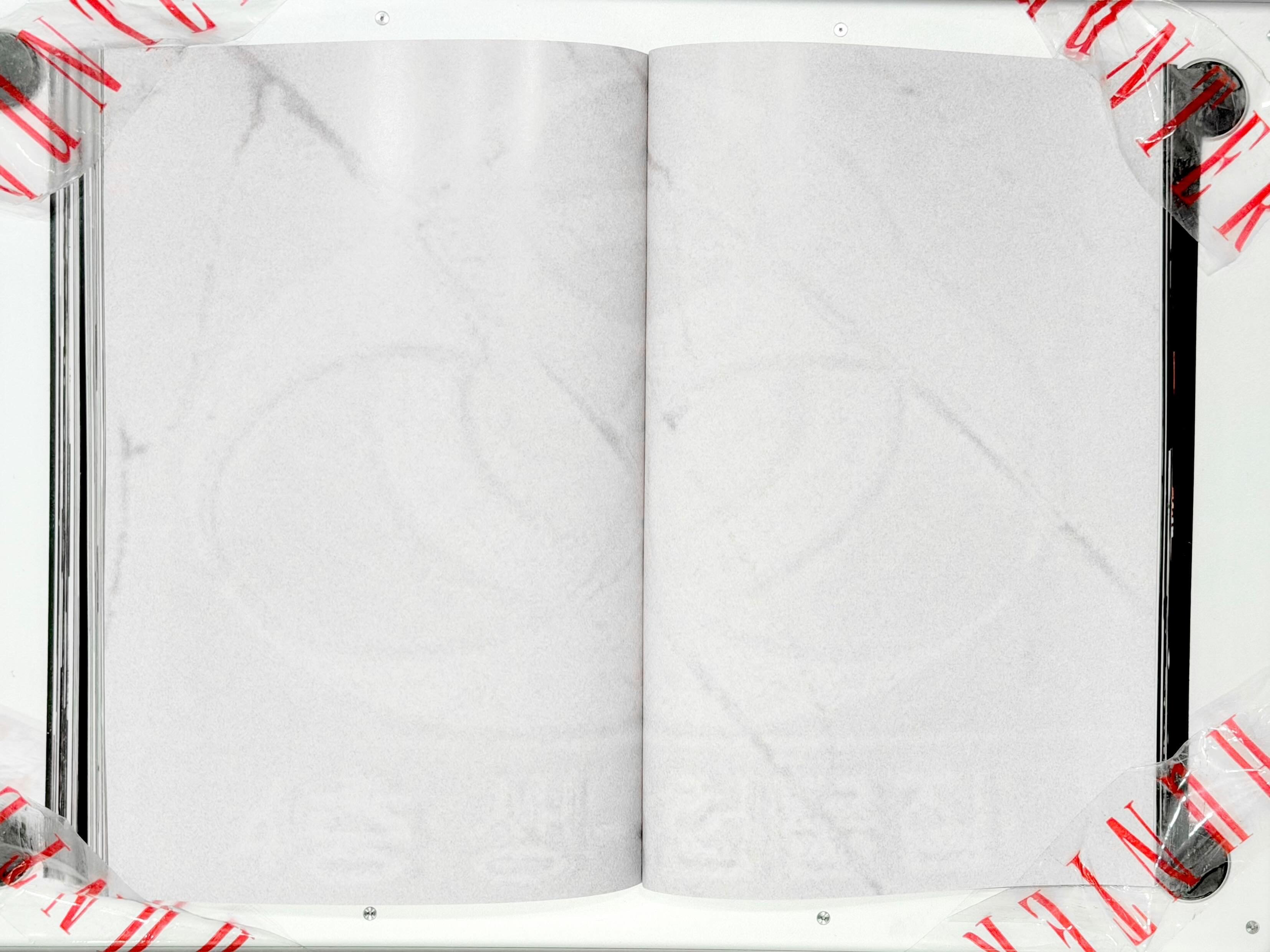 Spread from TheHunterIssue Vol.1 by Leo Shmunk, marble-paper pages with Chanel double-C surfacing as embossed pressure, brand-as-residue rather than logo, 2026. Photo: Leo Shmunk.