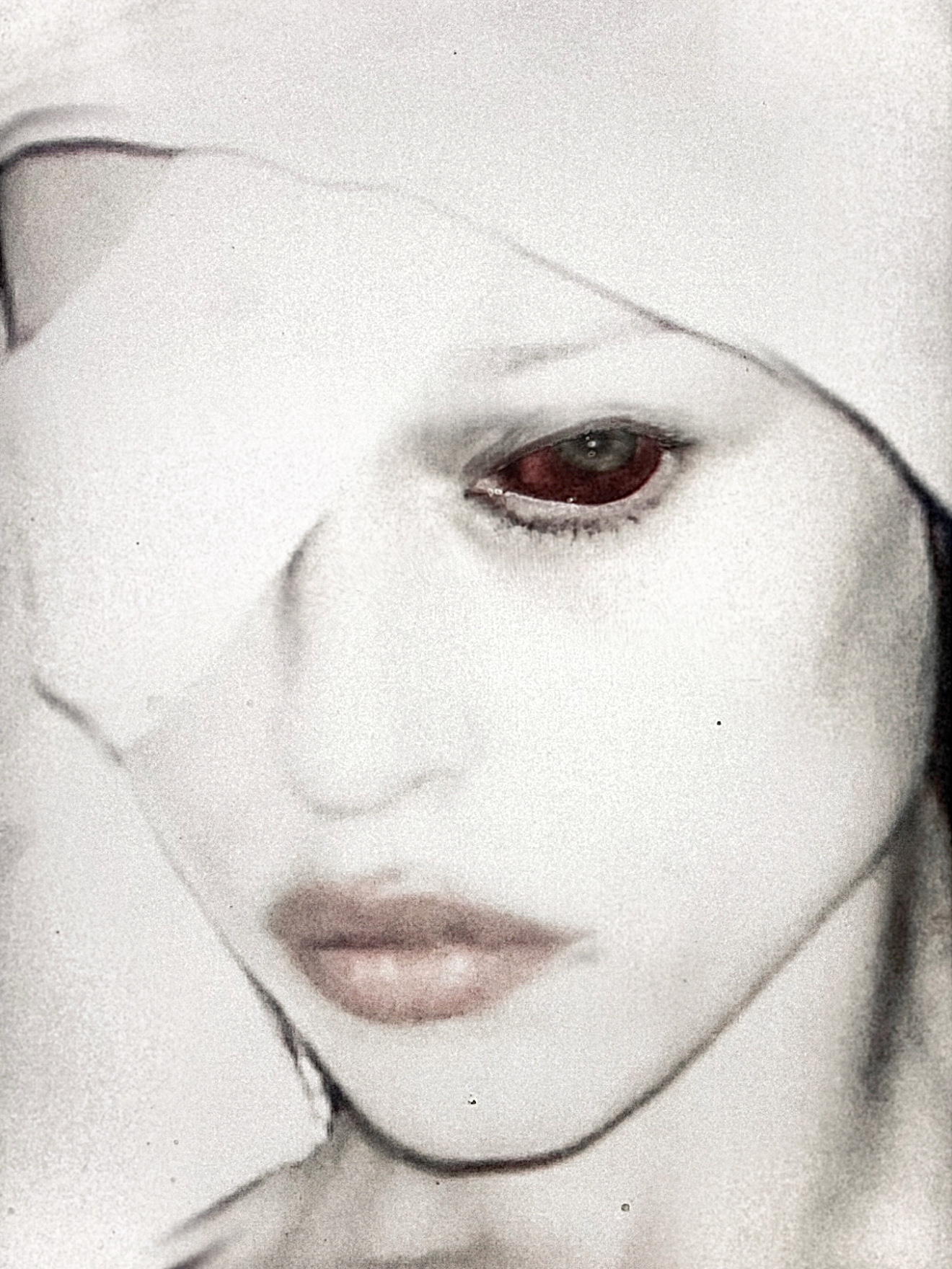Spread from TheHunterIssue Vol.1 by Leo Shmunk, close portrait of a face wrapped in translucent white fabric, one visible eye tinted blood-red, pale skin bleached into the veil, 2026. Photo: Leo Shmunk.