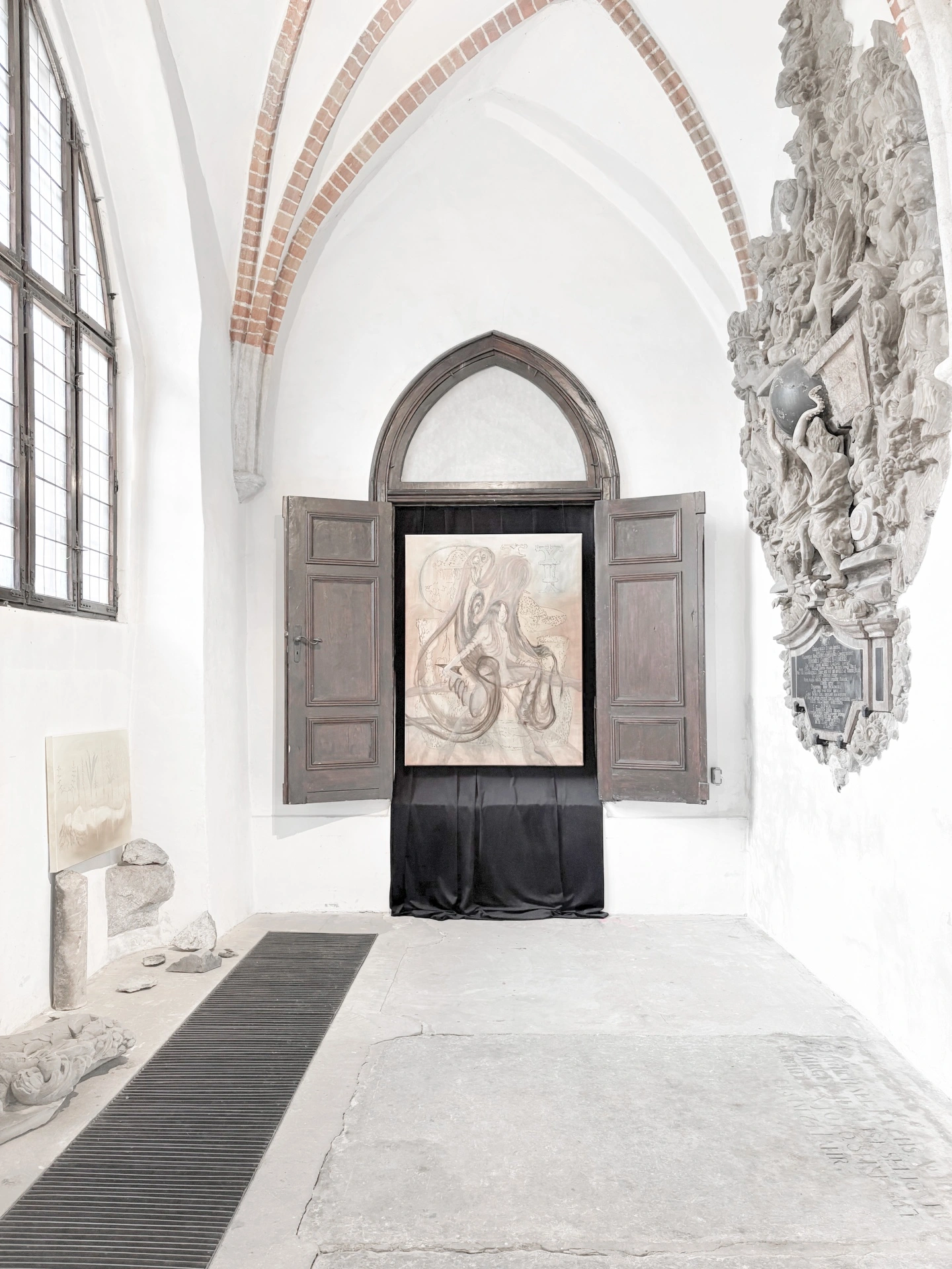 Angelika Puff, a curtained pale painting installed inside opened wooden double doors in the nave of Galeria EL, epitaph sculpture on the right wall.
