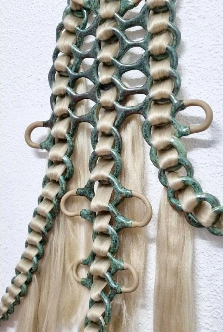 Sculpture detail, Seeds know no tree., New Fears Gallery, 2026: detail of bronze-green ceramic and hair wall sculpture, chain-link forms repeating, biological and architectural at once. Photo: Sandro Mosco