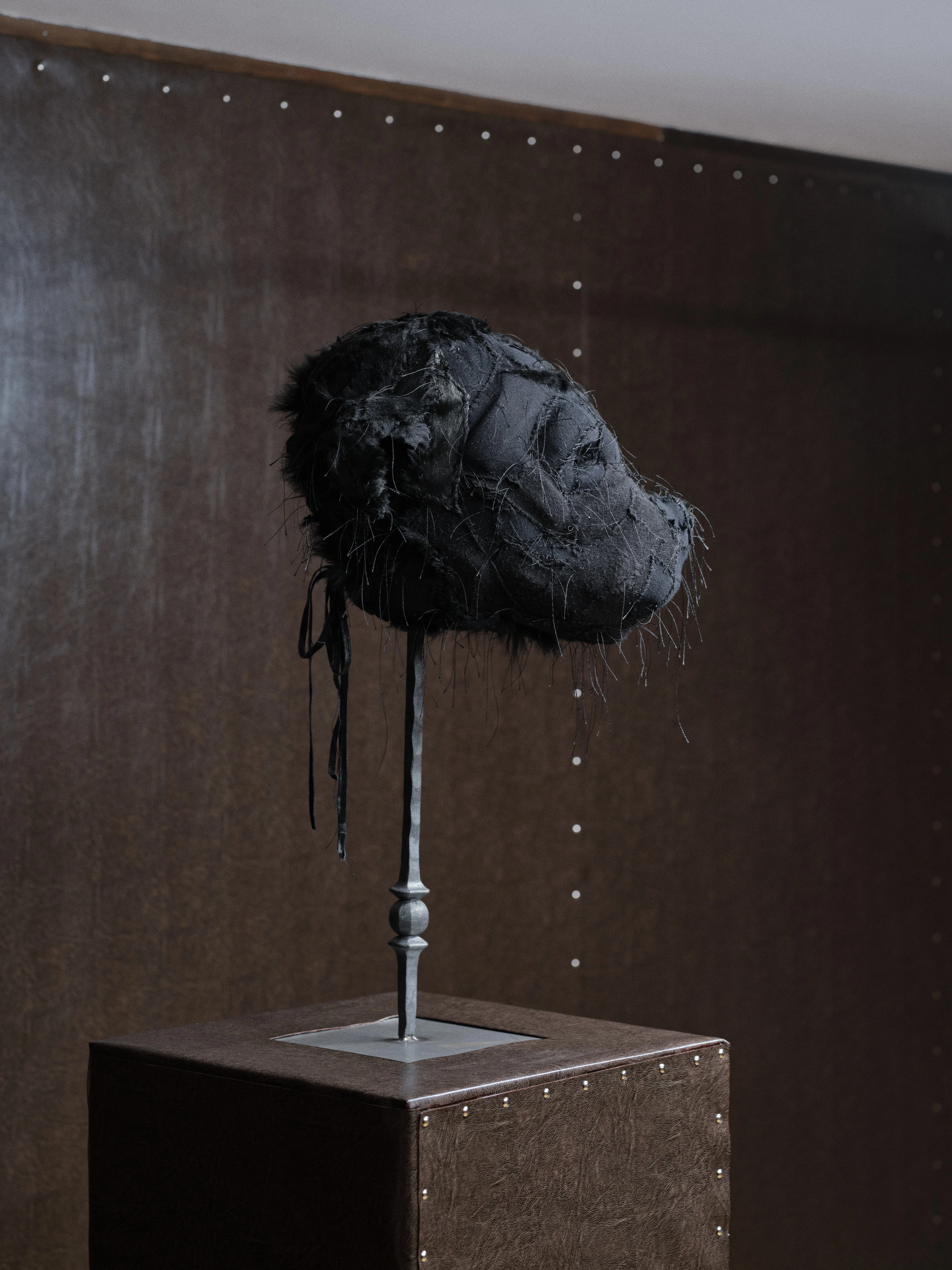 Jan Baszak, second Chihuahua Mask in profile with fur at the nape and long ribbon ties falling from the stand towards the plinth