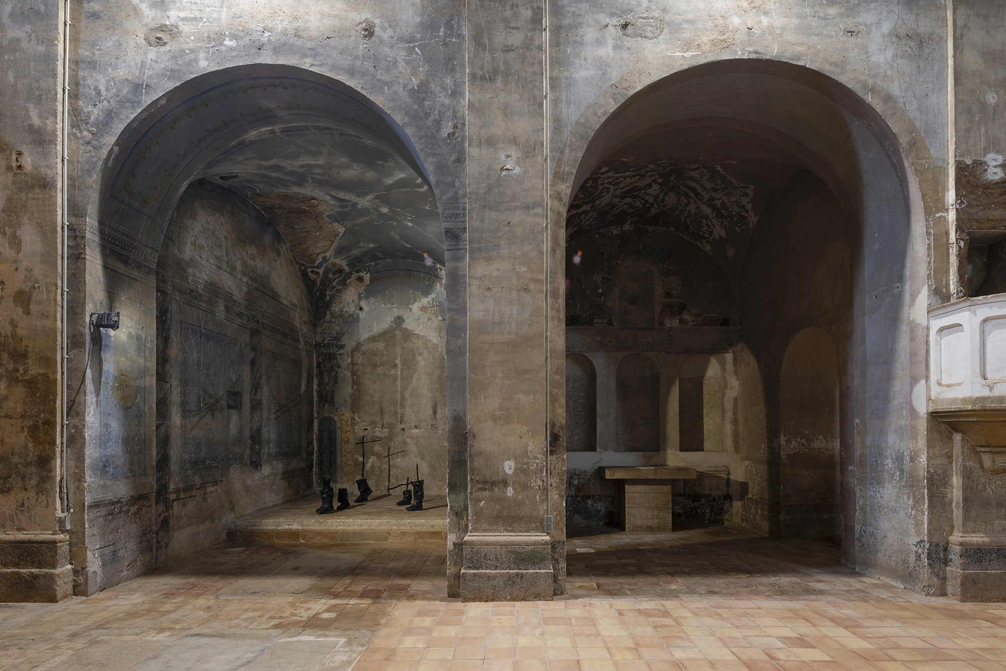 Installation view of KIN TOO in a side chapel of the Church of Sant Feliu, Lladó, seen through the nave arches.