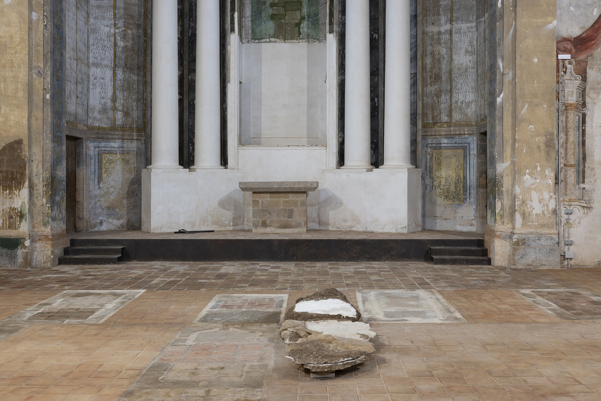 A work from Monia Ben Hamouda's Ghost series lying among the church's floor tombs before the altar steps.