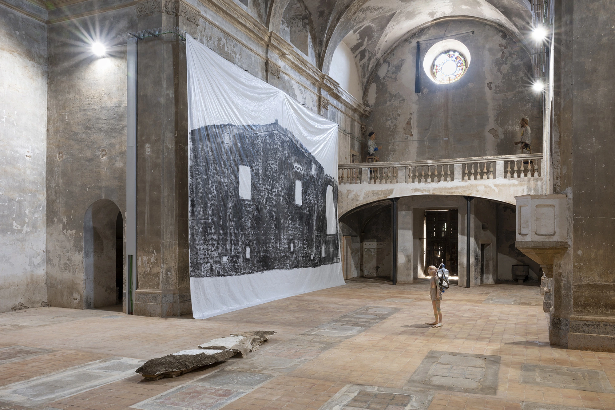 Installation view of KIN TOO with Andrew Birk's Floating House hung across the nave of the Church of Sant Feliu, Lladó.