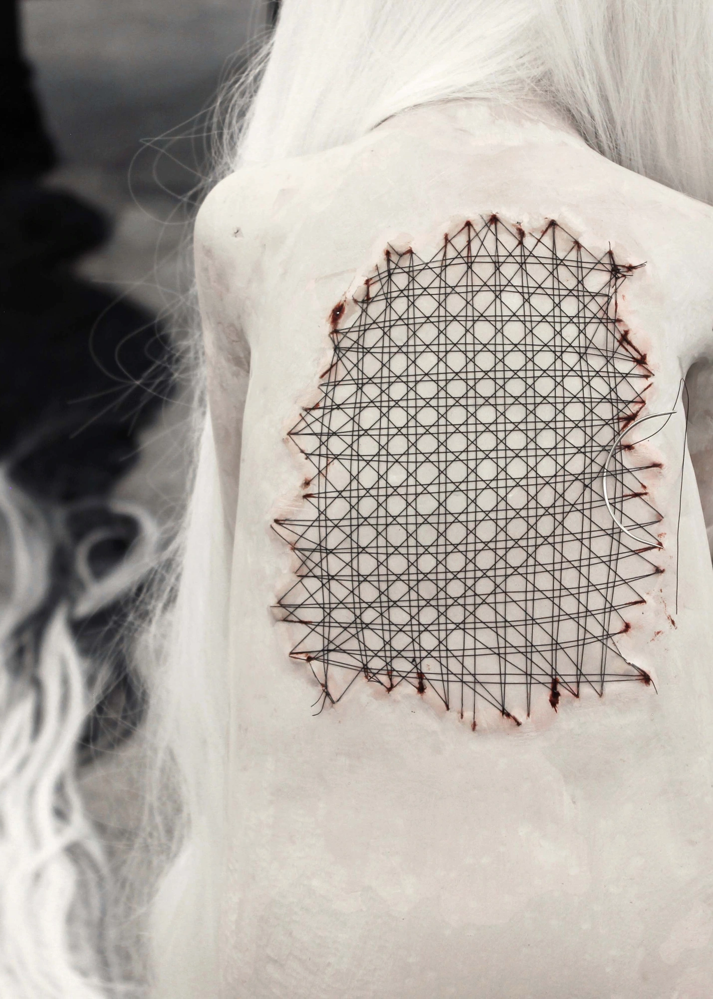 Alicia Bilbao, Orphaned Objecthood, 2025, detail of the stitched back. Epoxy clay, synthetic hair, wood, nylon thread, surgical needle, oil paint