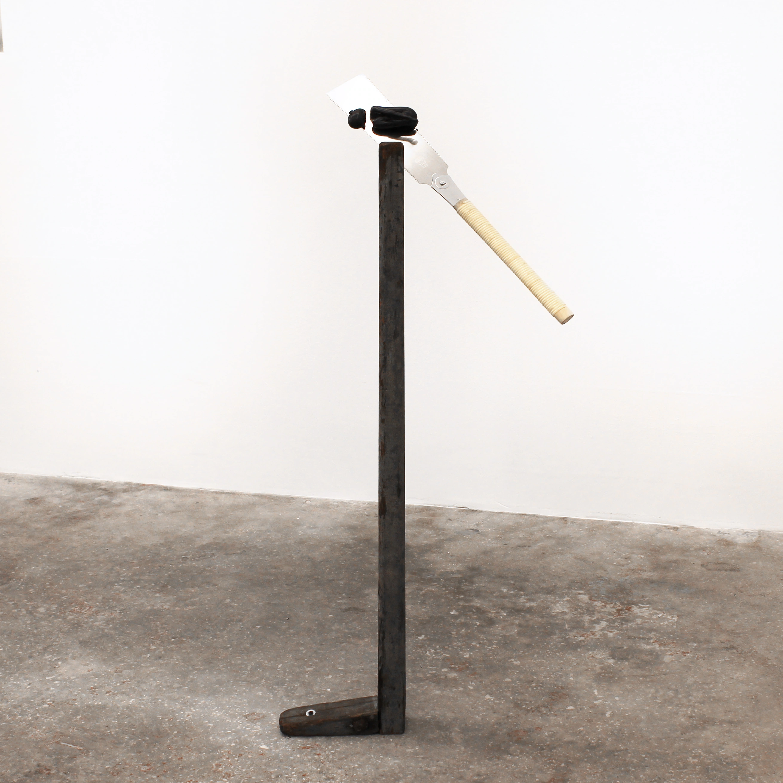 Alicia Bilbao, Executioner, 2026, full view. Epoxy clay, nokogiri saw, wood