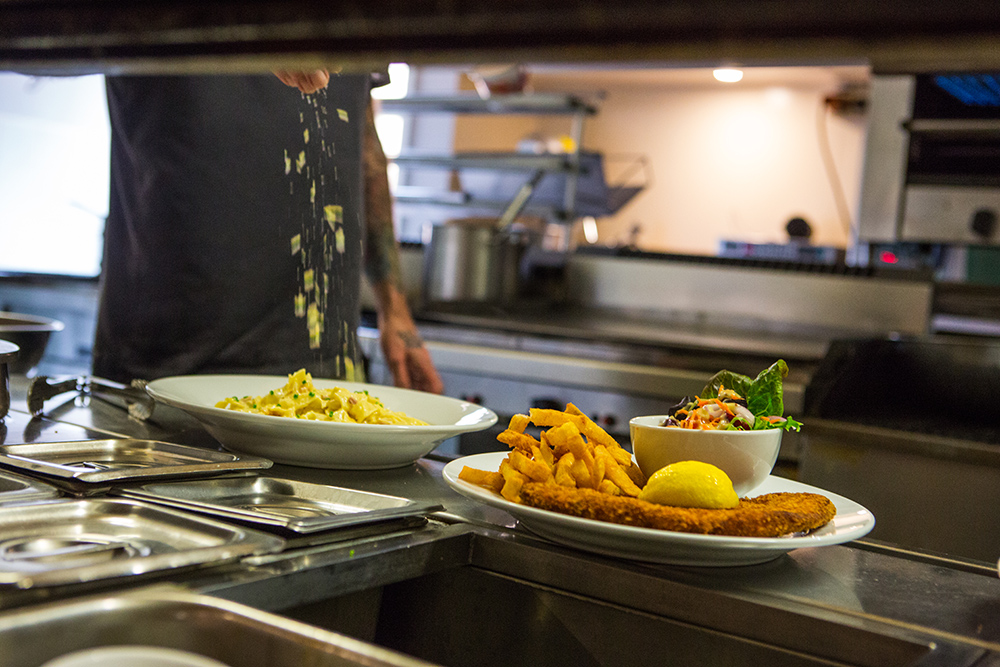 Pasta being prepared and coated with parmesan cheese
