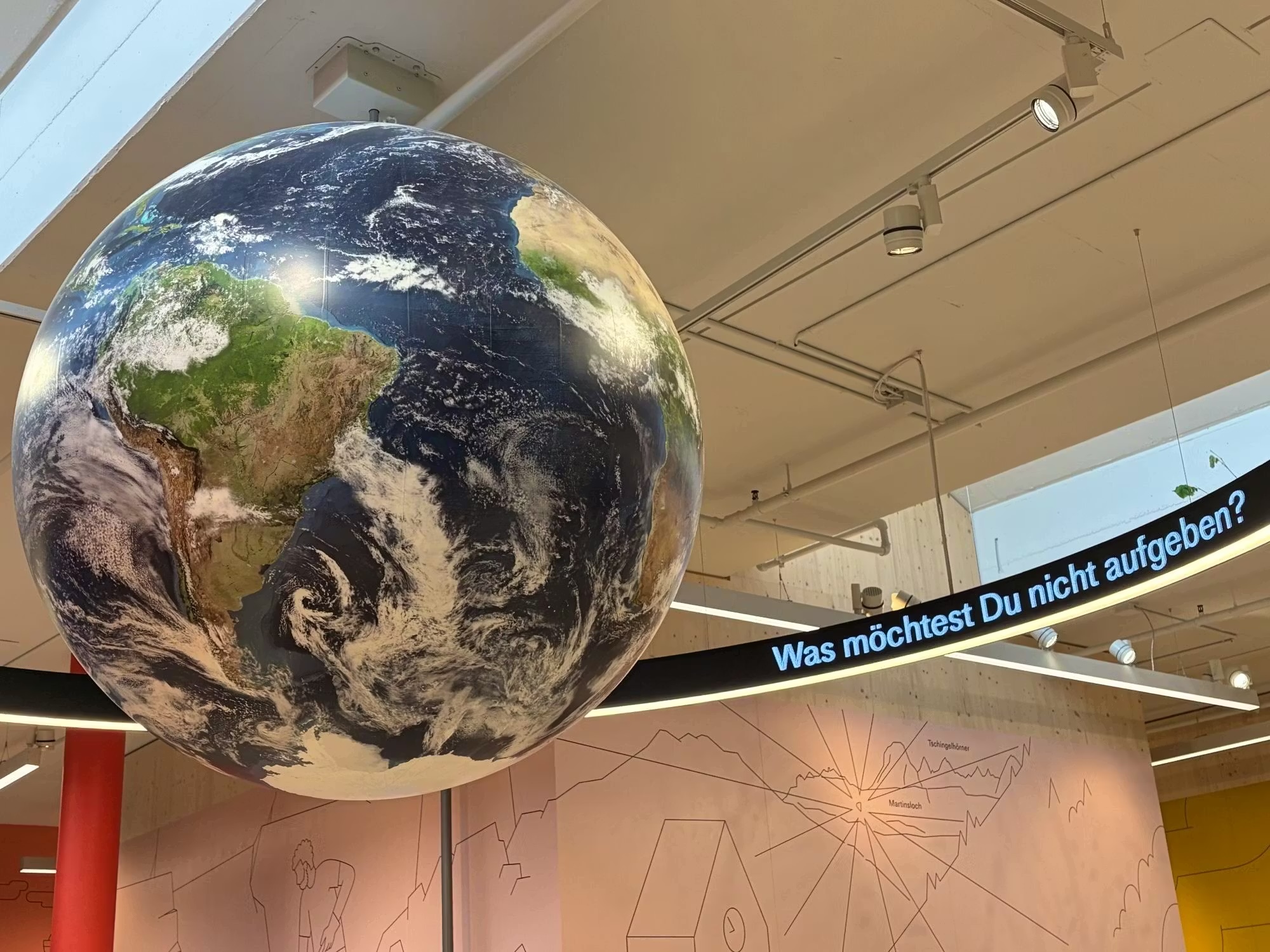 Beim Betreten der Ausstellung fällt der Blick als Erstes auf einen riesengrossen Erdball: Um den Planeten herum werden Fragen in den Raum gestellt.WSZ