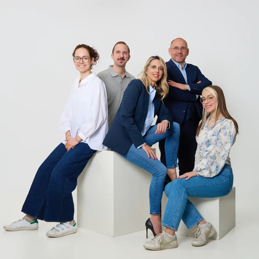 Équipe de cinq professionnels réunis dans un studio clair. Photographie corporate réalisée par Frédéric Sicard à Avignon.