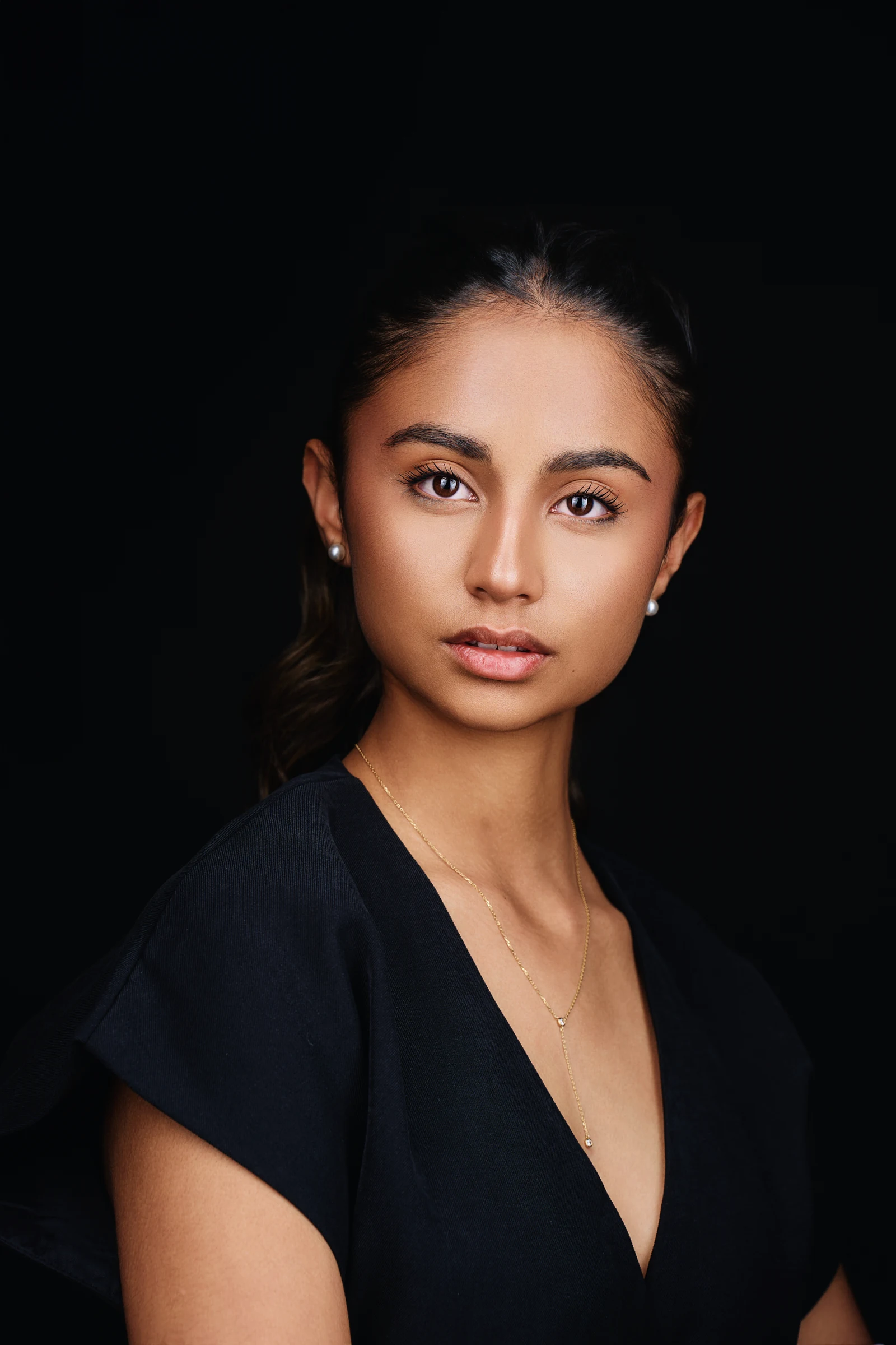 Portrait d’une adolescente en tenue noire sur fond sombre. Photographie réalisée par Frédéric Sicard au studio de Morières-lès-Avignon.