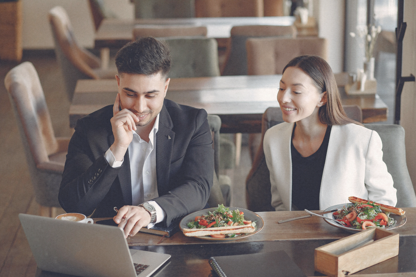 man and woman sitting at a table on a laptop