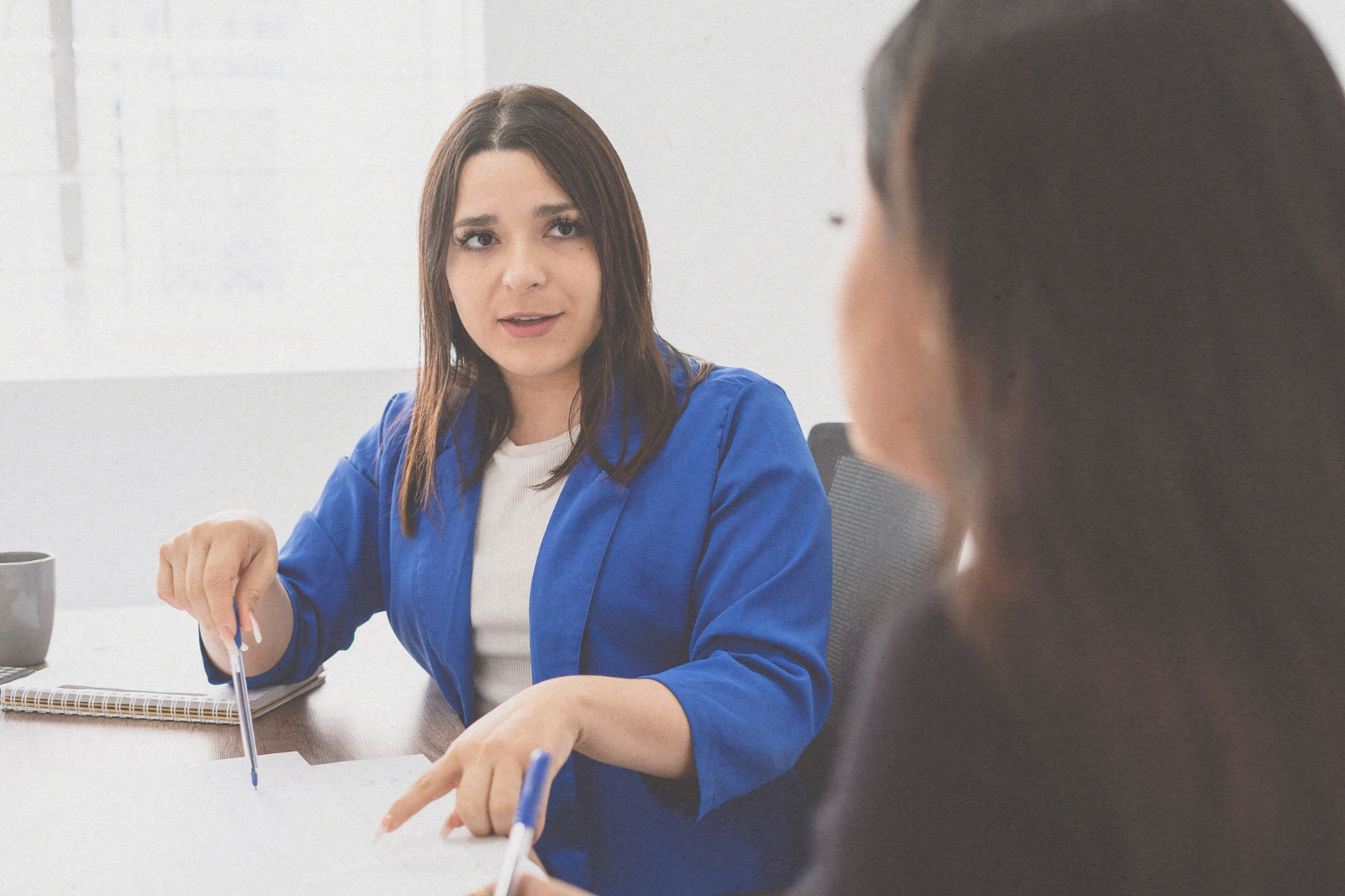 woman talking to another woman in a business meeting