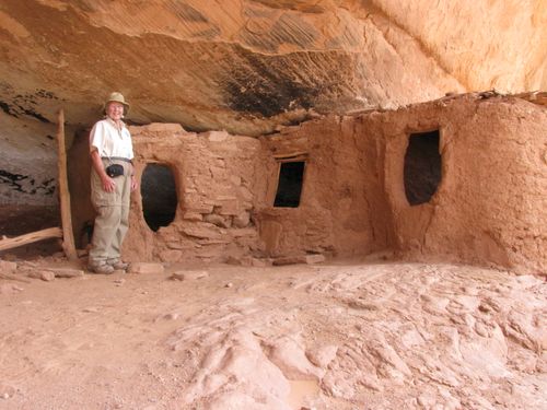Photo of Sugie Barker standing next to granery ruin at Moon House, Utah.