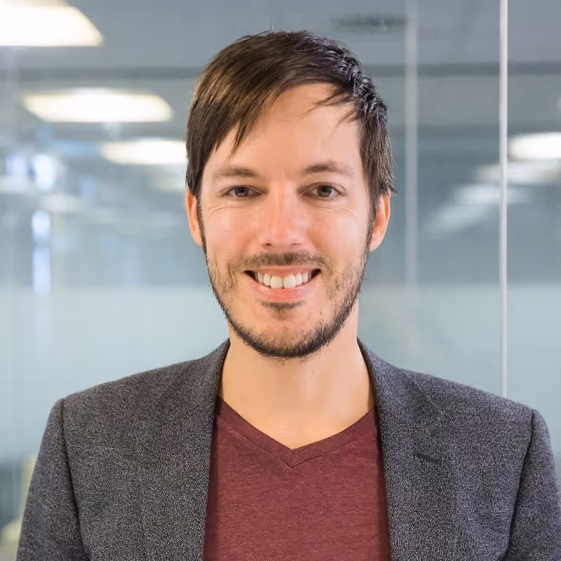 a man with a goatee smiles at the camera