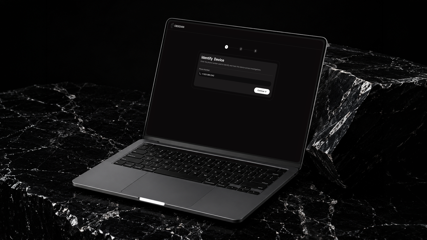 Laptop on black marble surface showing a dark-themed interface to identify device by phone number.