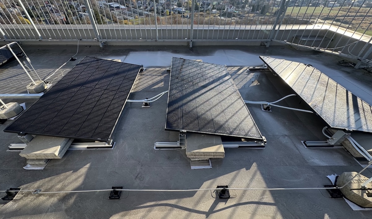 Domy sobě: Fotovoltaika pro bytové domy, detail solárních panelů z probíhající instalace na klíč.