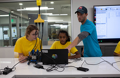 A student drawing an illustration of a shark in chalk
