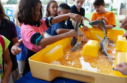 Two students with an instructor exploring STEM related technology at the SPID Science Festival