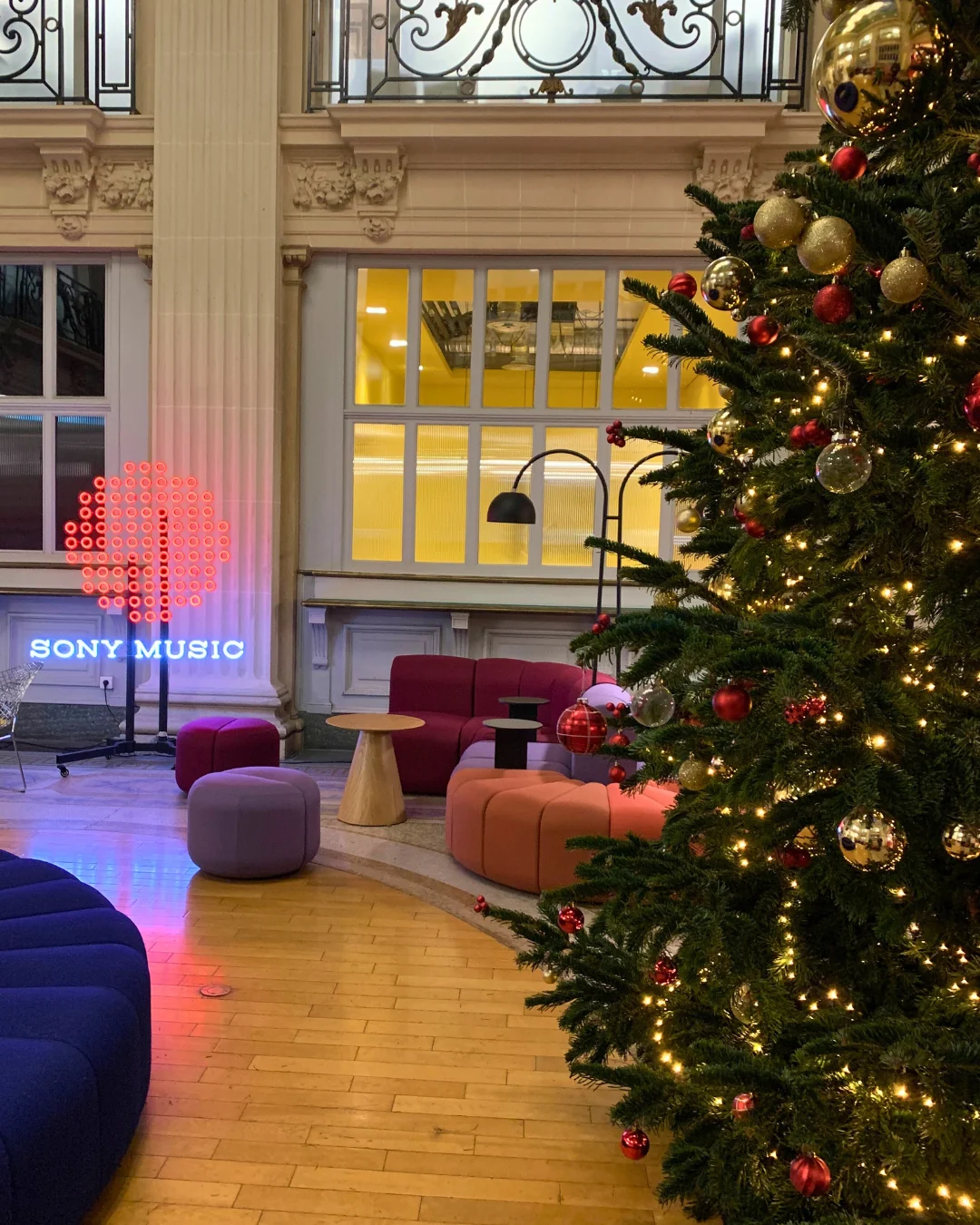 Grand sapin de Noël illuminé dans le hall d'un immeuble de bureaux
