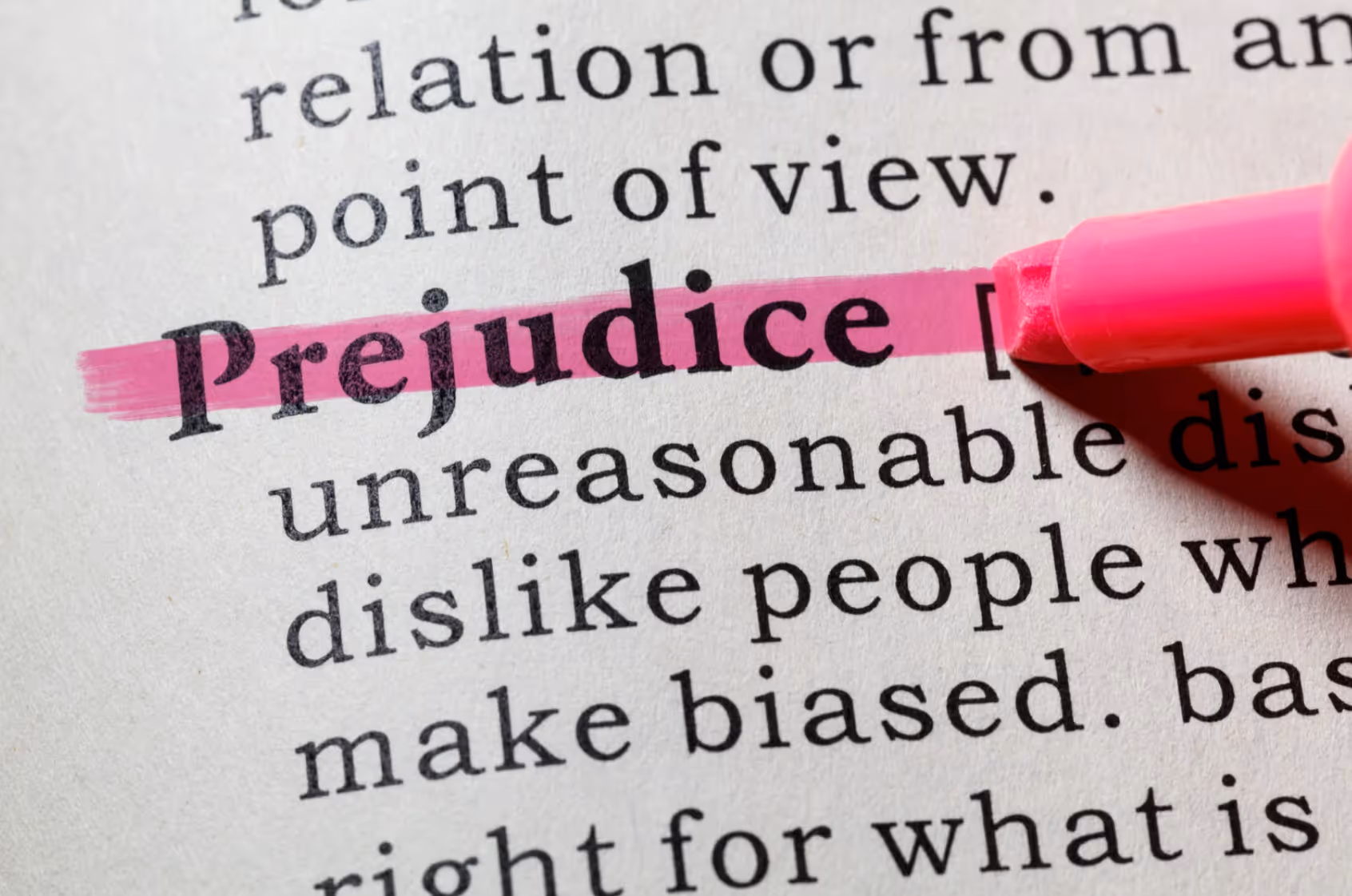 Das Wort ‚Prejudice‘ im Wörterbuch mit pinkem Textmarker hervorgehoben – Symbolbild für unbewusste Vorurteile und Unconscious Bias im Alltag