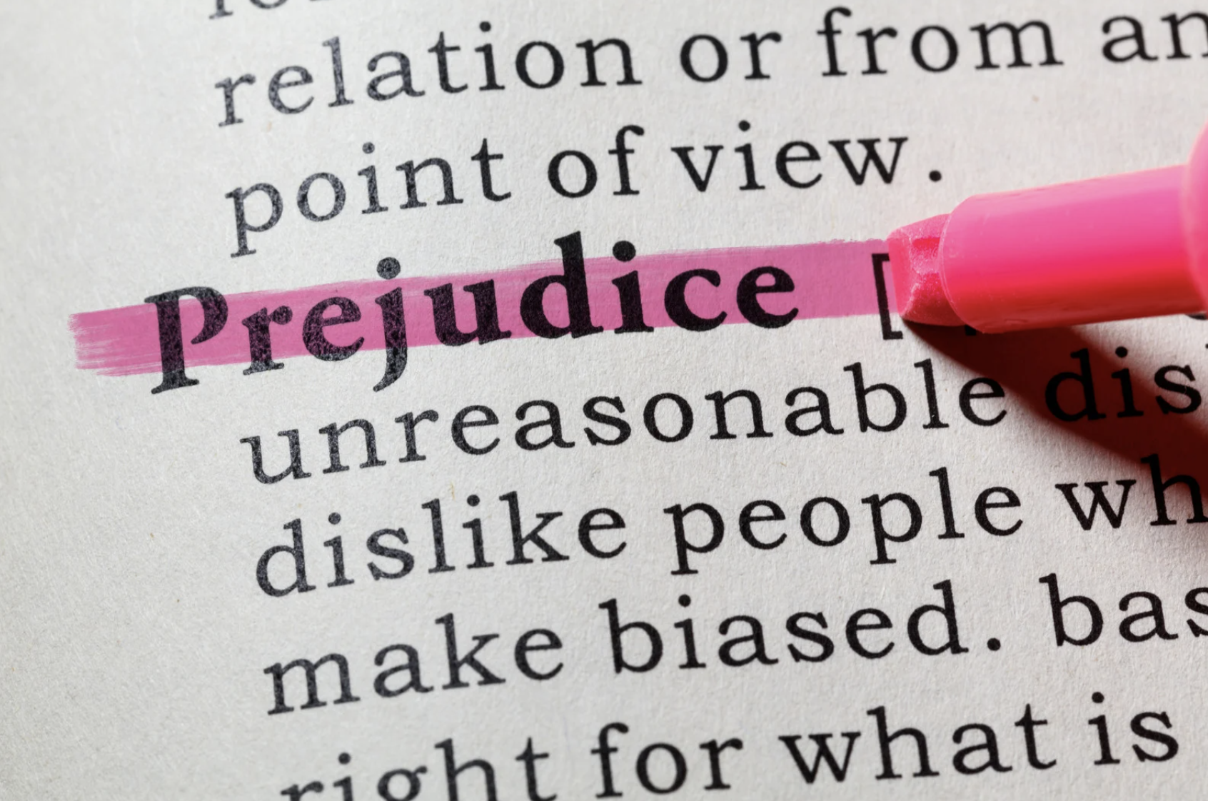 Das Wort ‚Prejudice‘ im Wörterbuch mit pinkem Textmarker hervorgehoben – Symbolbild für unbewusste Vorurteile und Unconscious Bias im Alltag