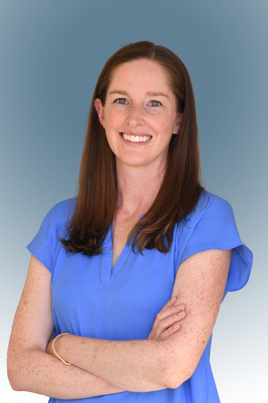 Smiling woman in blue medical scrubs