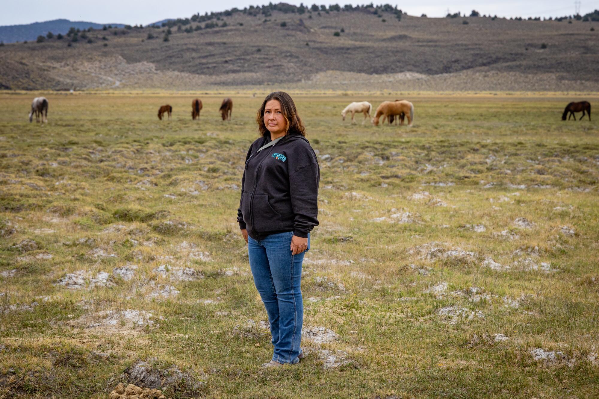 Ronda Kauk stands near wild horses.