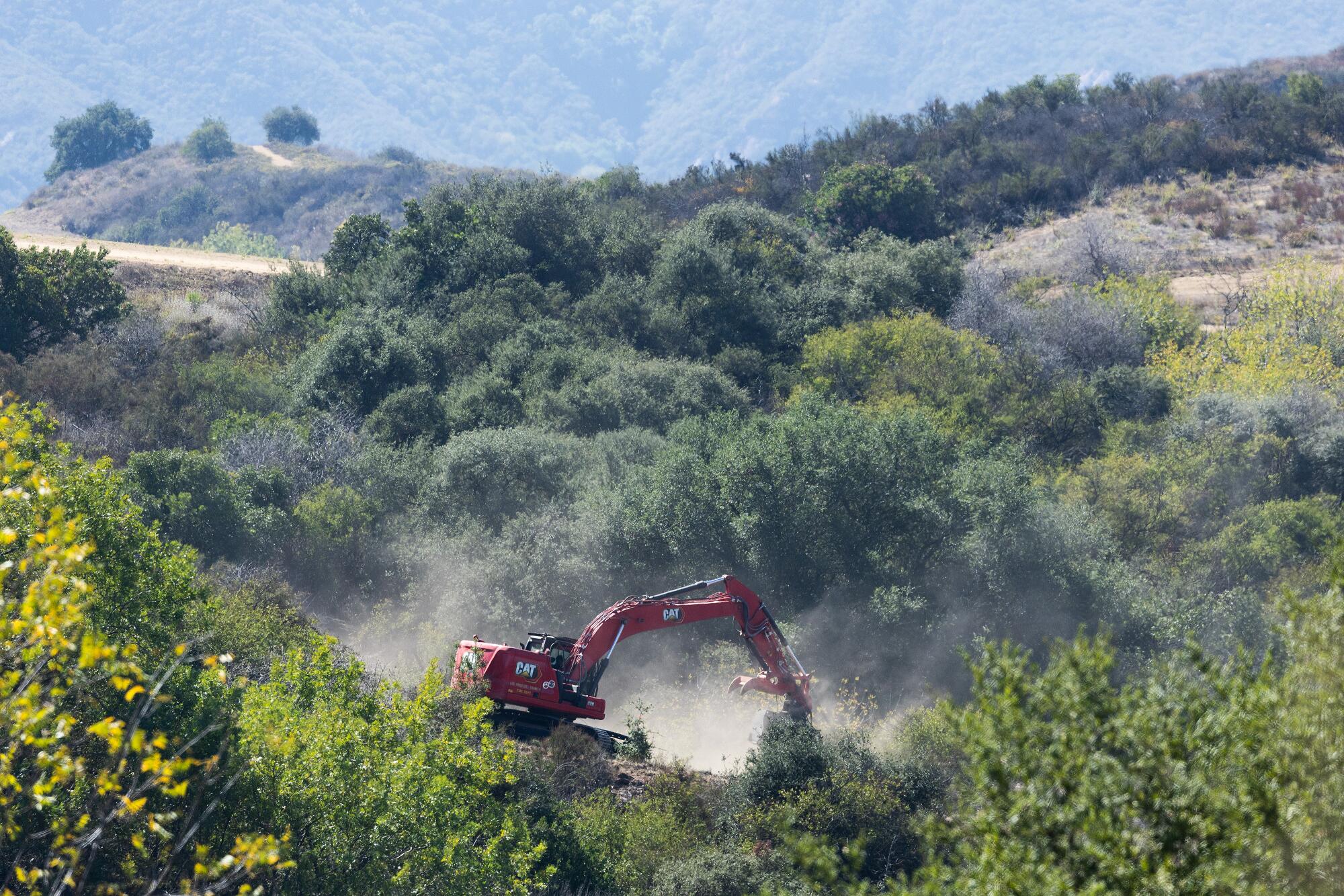 A Los Angeles County Fire Department excavator clears vegetation in the Santa Monica Mountains on Wednesday, Oct. 8, 2025.