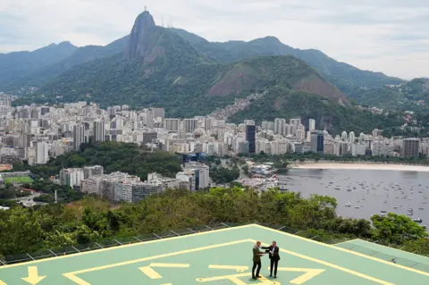 PA Media The Prince of Wales (left) is presented with the keys to the city by the Mayor of Rio de Janeiro, Eduardo Pae - with Rio in the background