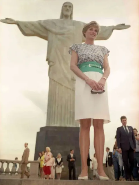 Associated Press She is wearing a white, knee-length skirt with a bright green waistband and belt, and a short-sleeved 