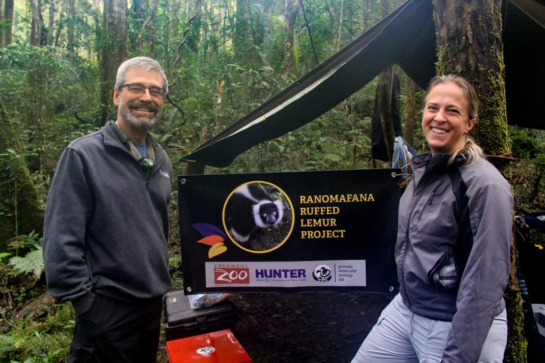 two researchers stand in front of a sign that reads Ranomafana ruffed lemur project