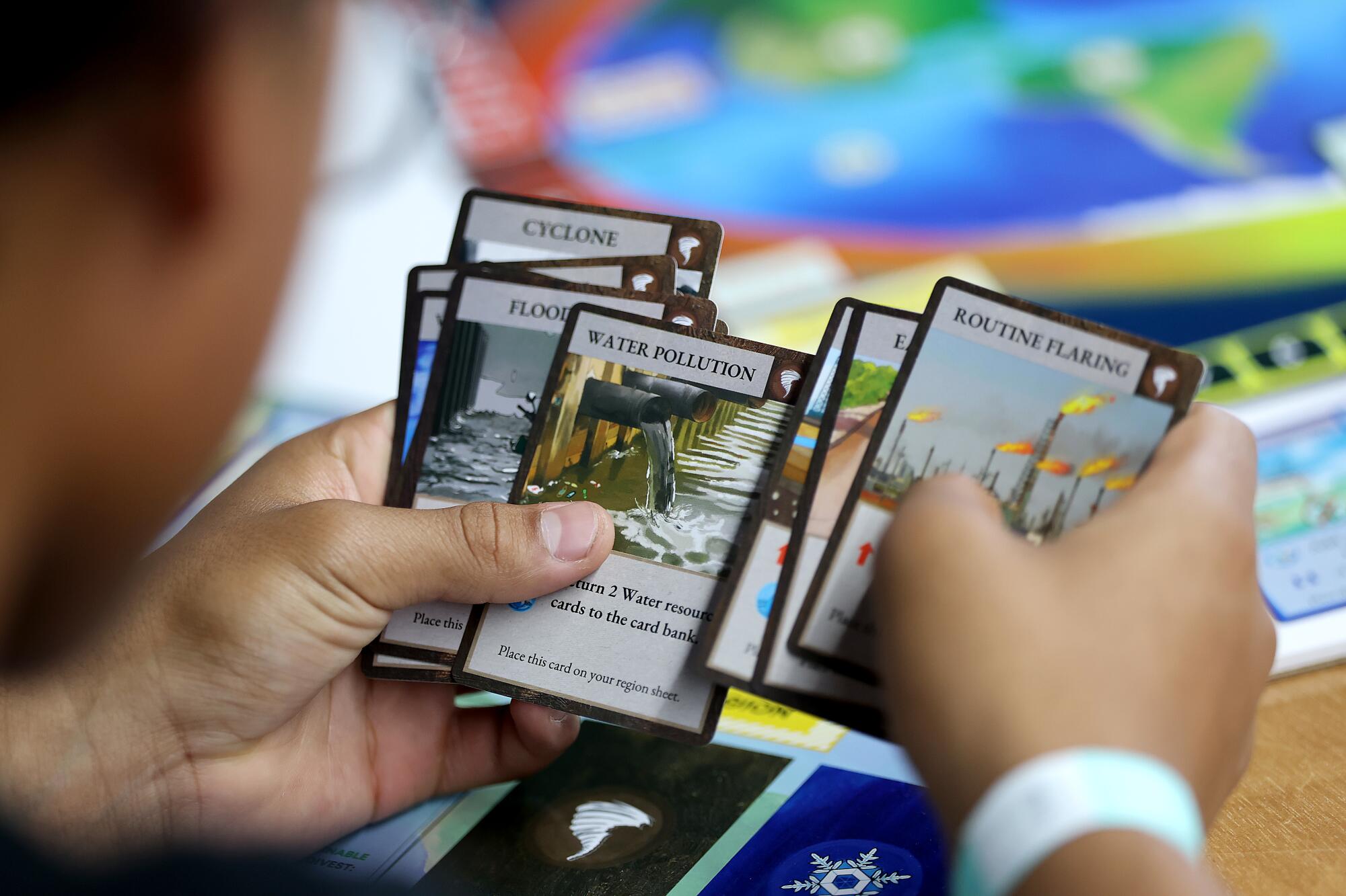 Golden Valley Middle School student Matthew Quintero looks through cards while learning about climate solutions.