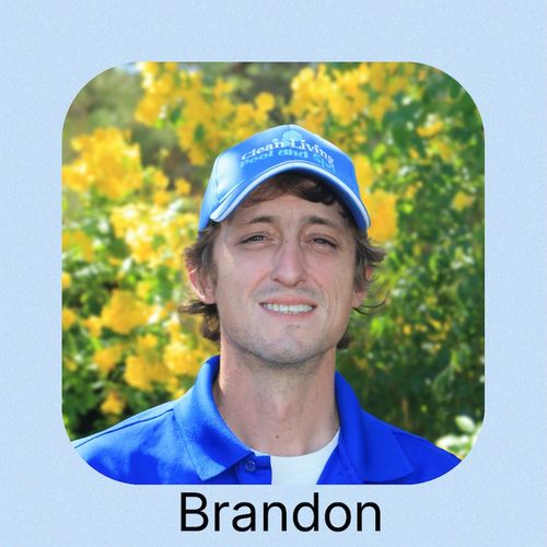 A man in a blue shirt and cap stands near a tranquil pool