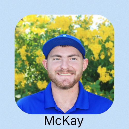 A person in a blue shirt sits by a serene water scene