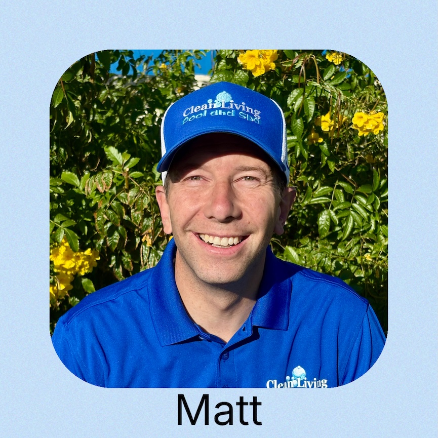 A person wearing a blue cap and shirt poses in front of a calm water