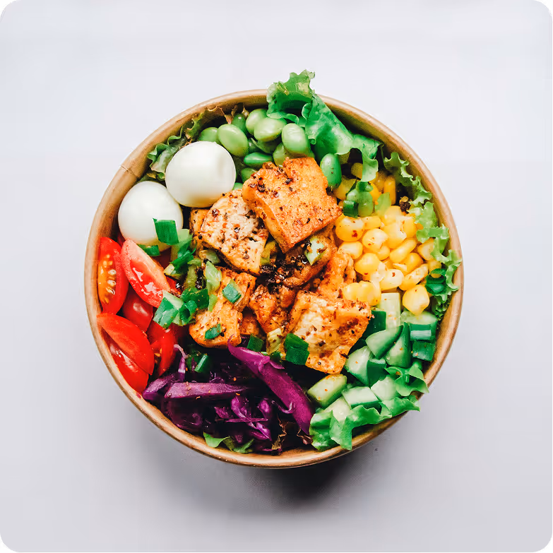 A nutritious bowl with grilled chicken, fresh vegetables, and eggs.