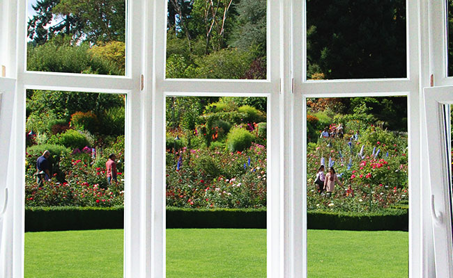 white PVC segmented glass window joinery overlooking garden 