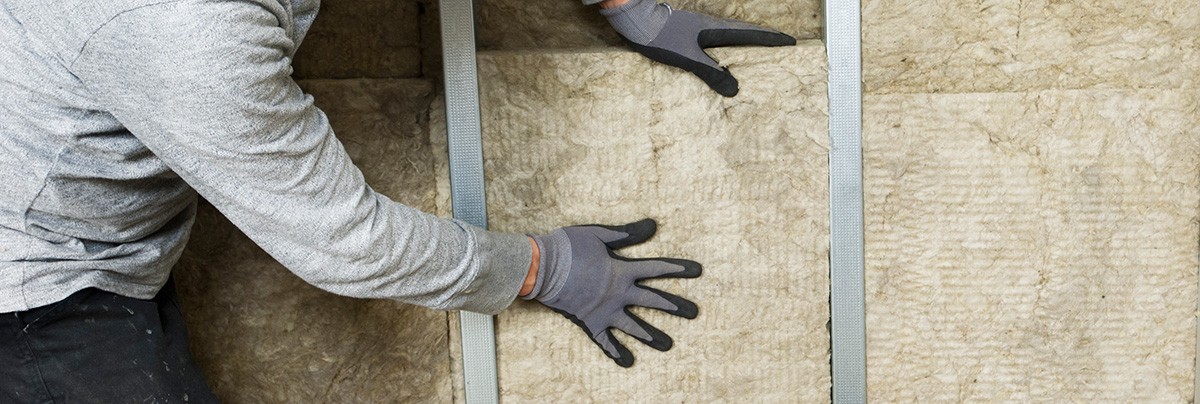 Person placing insulation into walls making a home healthier and Eco-friendly.